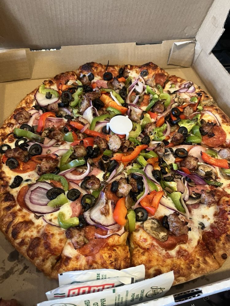 Gabilan combination pizza with browned cheese, peppers, olives and meat in its box
